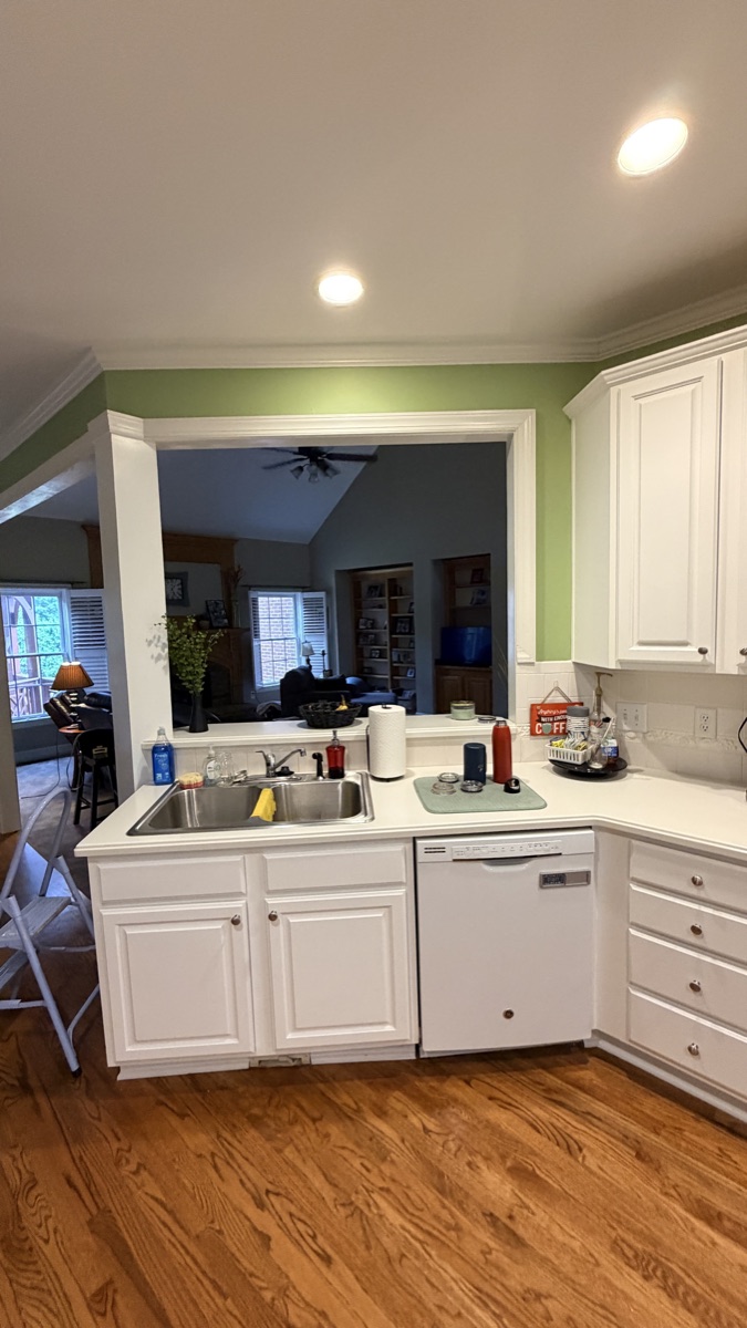 Recently painted white kitchen peninsula cabinets with a sink